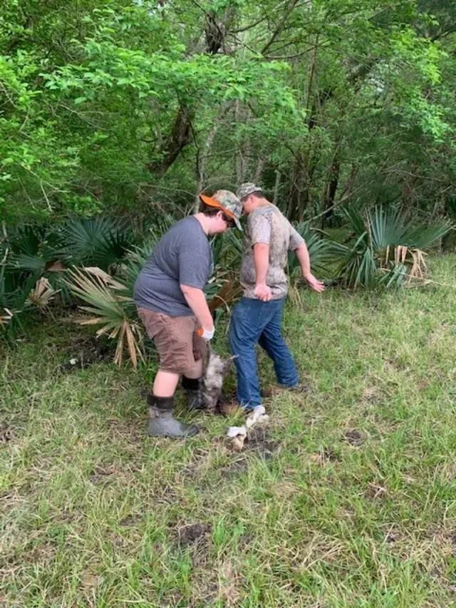 Two men and a dog in the woods.