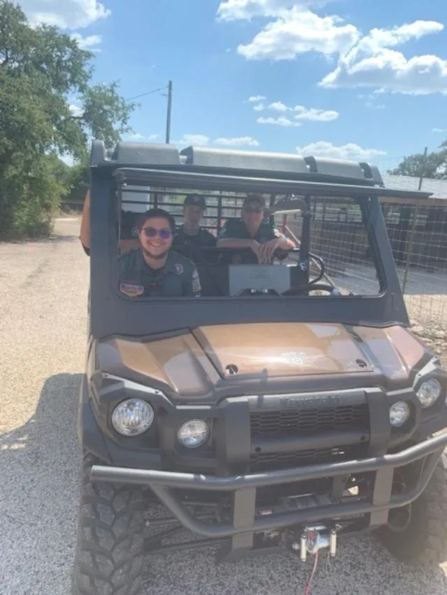 Two people in a vehicle with one sitting on the front seat.