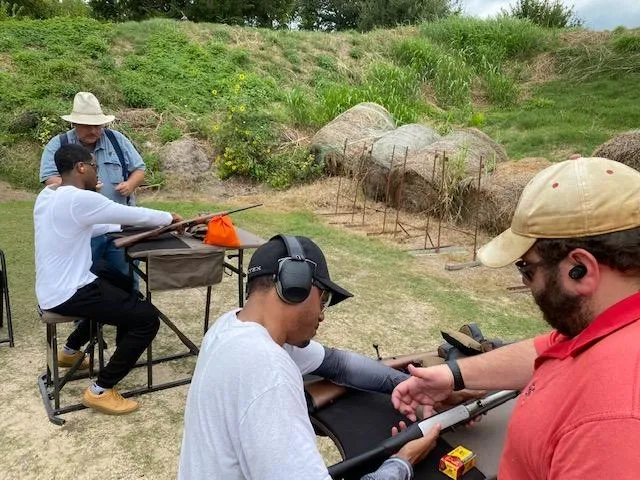 A group of people with guns in the grass.