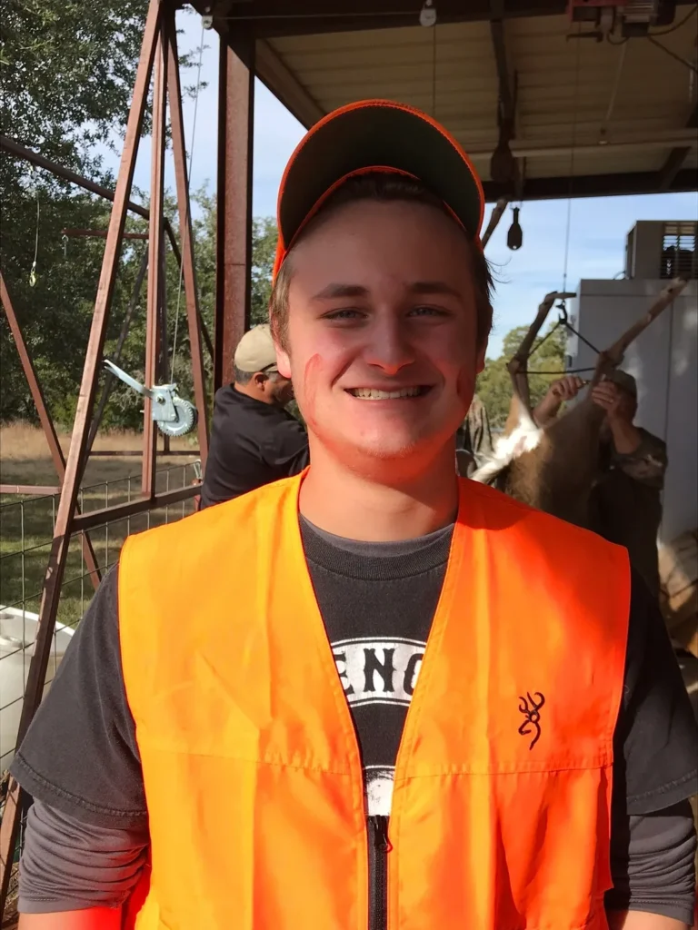 A man in an orange vest and hat.