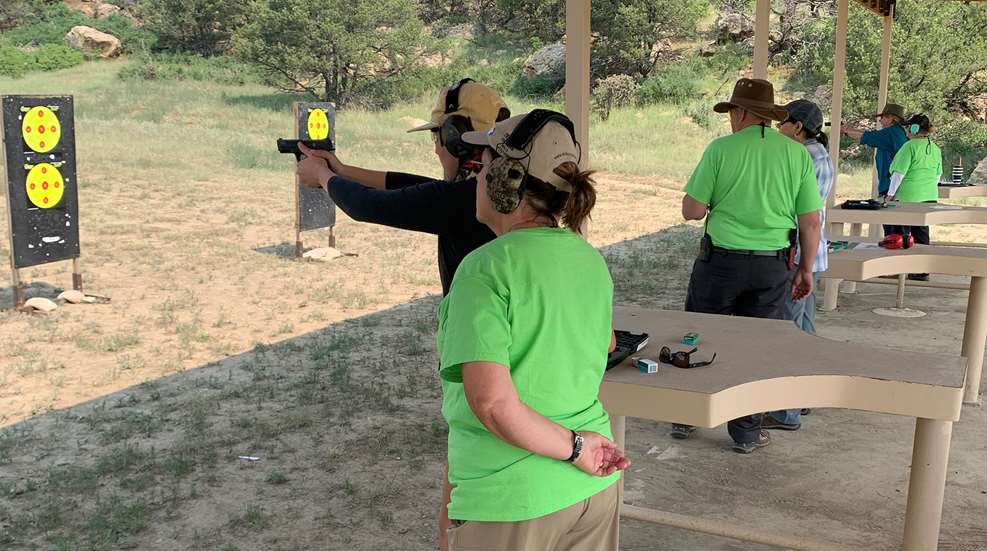 A man and woman are practicing shooting at the range.