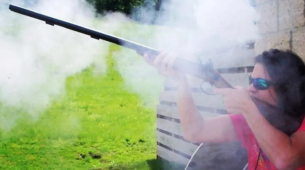 A person holding a gun and aiming it at something