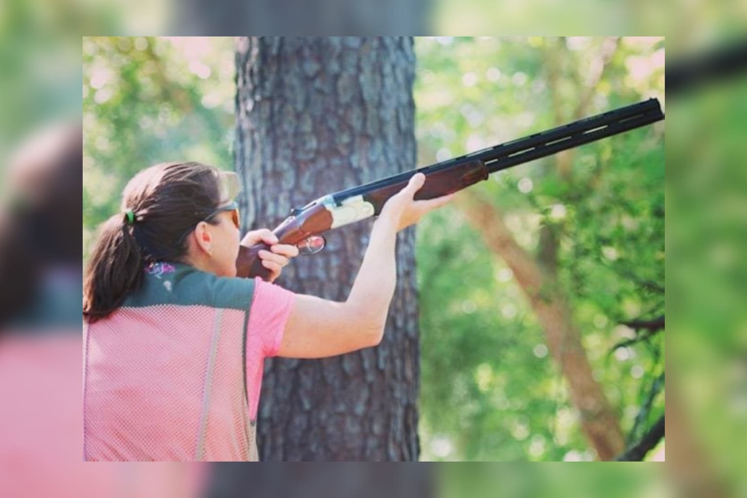 A woman is holding a gun in her hand.