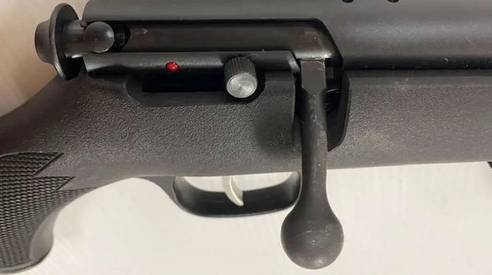 A close up of the trigger on an automatic rifle.