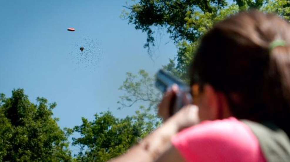 A person taking a picture of kites flying in the sky.