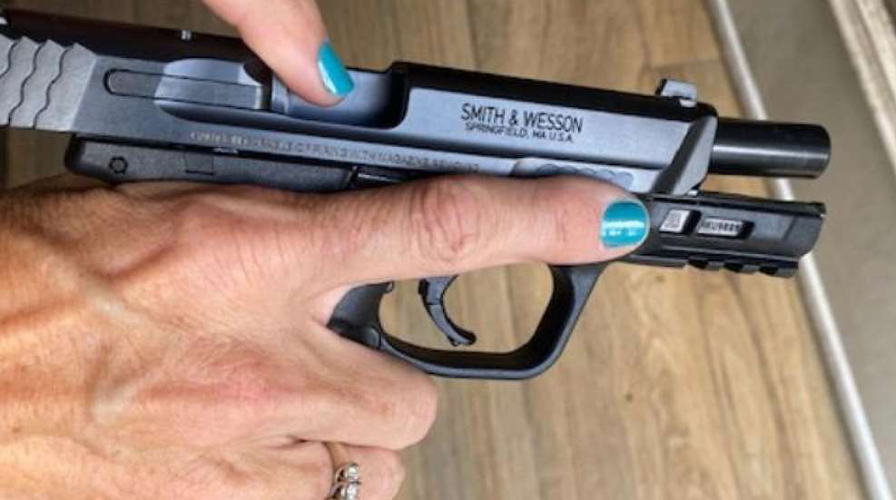 A person is holding a gun with the word smith & wesson on it.