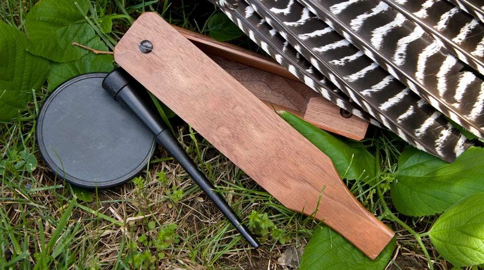 A wooden paddle and an umbrella laying on the ground.