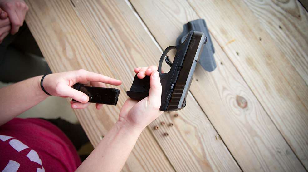 A person holding a gun in their hand.