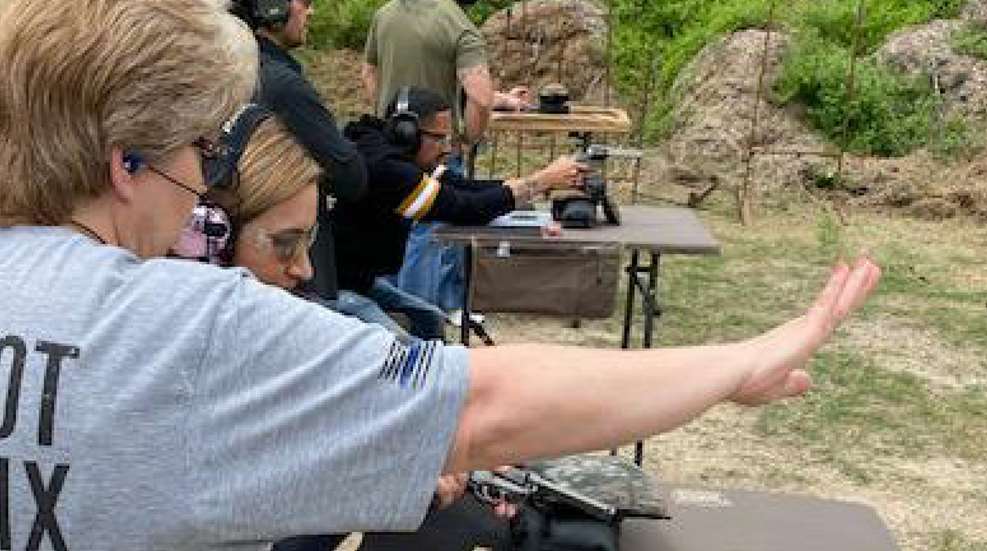 A group of people are practicing shooting at an outdoor range.