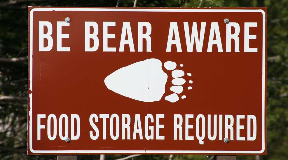 A sign that says the bear awaits food storage required.