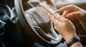 A person is holding their phone while driving.