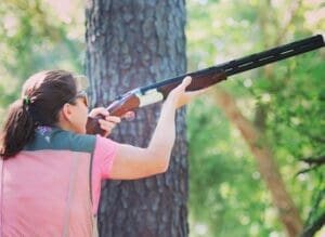 A woman is holding a gun in her hand.