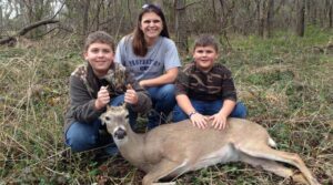 A family with a deer in the woods