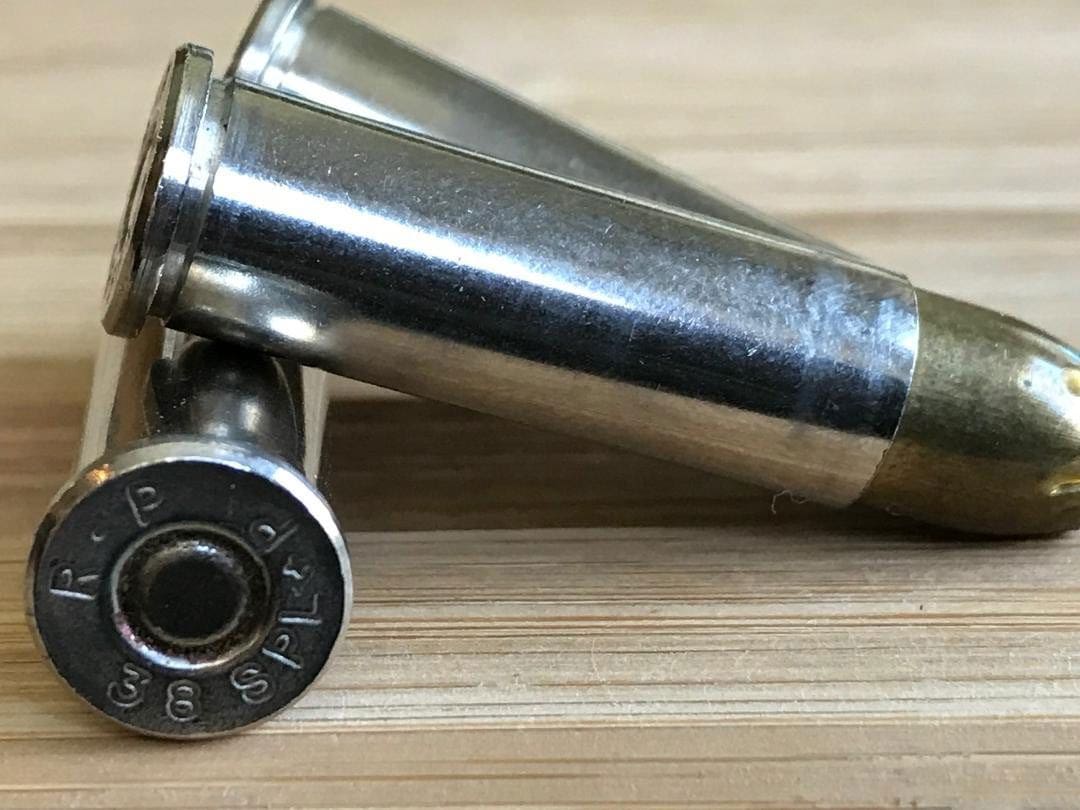 Three nickel-plated pistol cartridges.