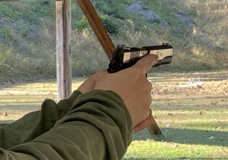 A person holding a gun in their hand.