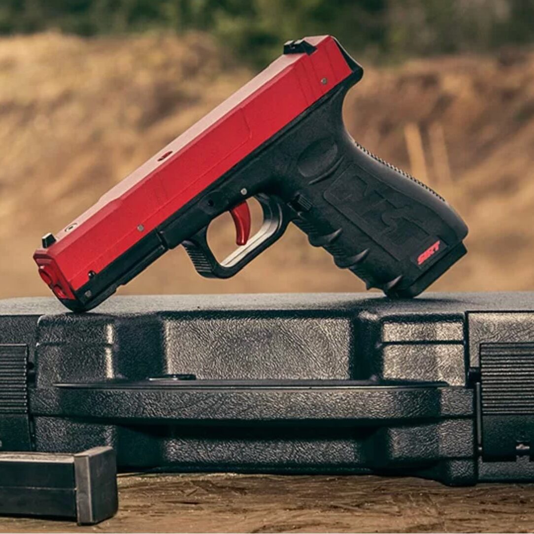 A red and black gun sitting on top of some boxes.